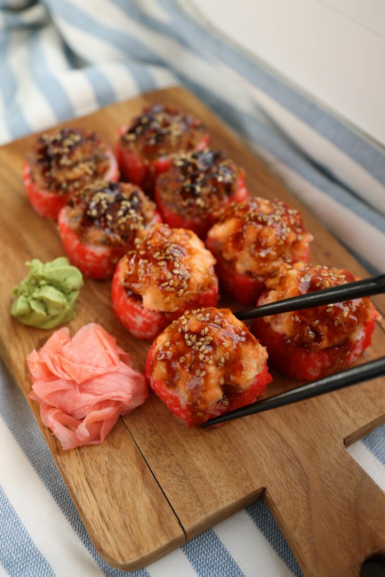 Appetizing spicy sushi rolls on a wooden board with wasabi and ginger. Perfect for food photography.