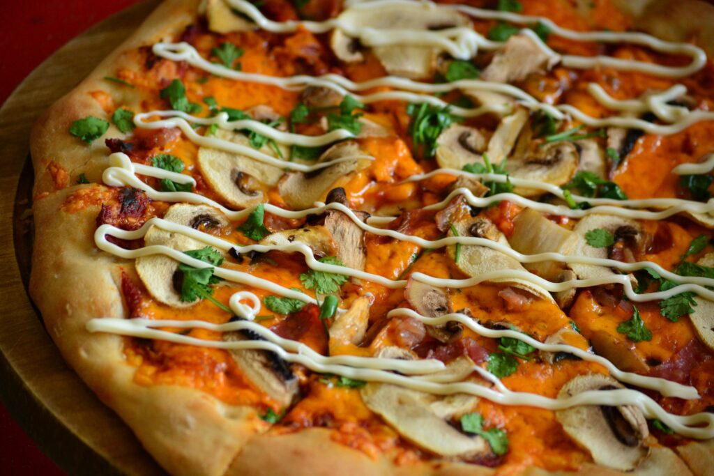 Delicious mushroom pizza with creamy toppings and fresh herbs in close-up.