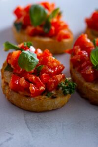 Delicious Italian bruschetta topped with fresh tomatoes and basil leaves, perfect for a snack.